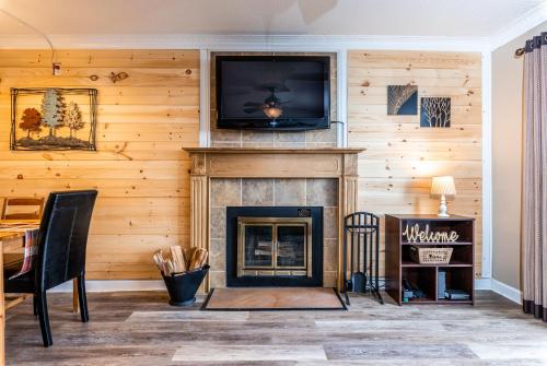 a living room with a fireplace with a tv above it at SKY HIGH VIEWS!!-Peak Mountaintop-Outdoor Pool-Close to Downtown-Private Balcony-WiFi-Cable in Gatlinburg