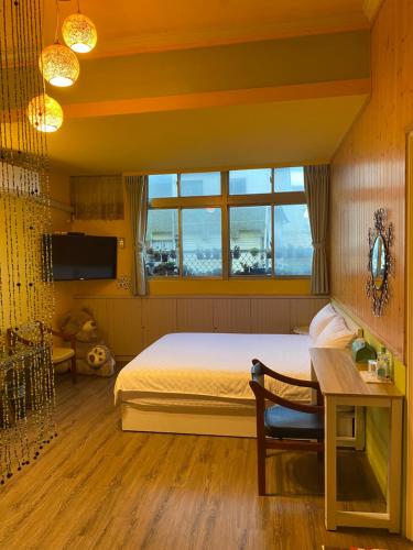 a bedroom with a bed and a desk and a window at 叁樓民宿 in Taitung City