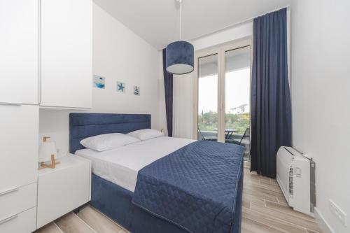 a bedroom with a blue bed and a window at La barca apartments in Becici