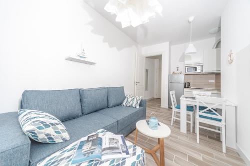 a living room with a blue couch and a kitchen at La barca apartments in Becici
