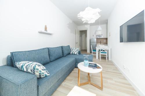 a living room with a blue couch and a table at La barca apartments in Becici