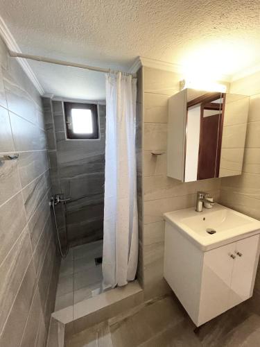 a bathroom with a sink and a toilet and a shower at Ostraco Aphytis in Afitos