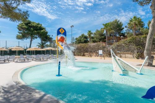 a water fountain in a swimming pool in a resort at Can Picafort Palace in Can Picafort