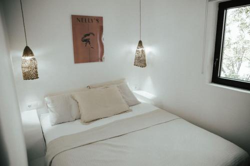 a white room with a bed and a window at Sol living in Tinos