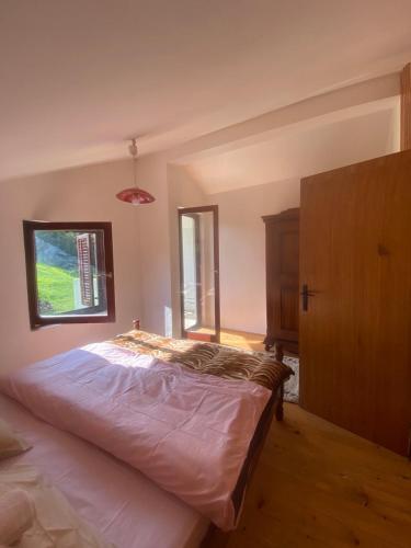 a bedroom with a large bed and a window at Kuca Dacica in Žabljak
