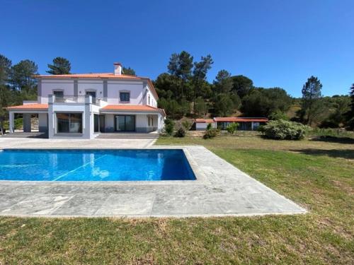 une villa avec une piscine en face d'une maison dans l'établissement Quinta Grande, à Chamusca