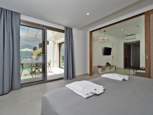 a bedroom with a bed and a view of the ocean at Hotel Athina in Agios Stefanos