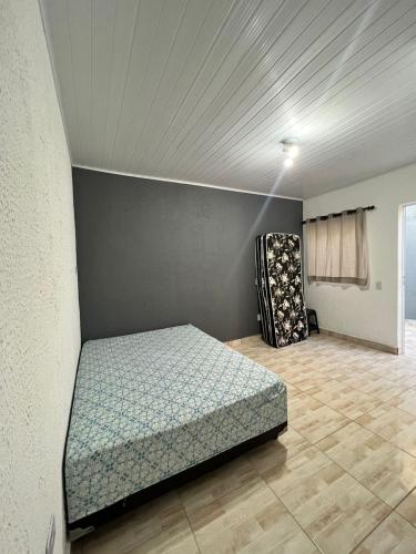 ein Zimmer mit einem Bett und einem Stuhl darin in der Unterkunft GL Pousada in Guarujá