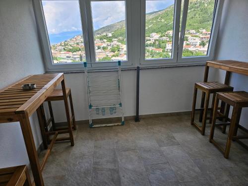 a room with two chairs and a table and two windows at BC Bikers Welcome Apartments in Senj