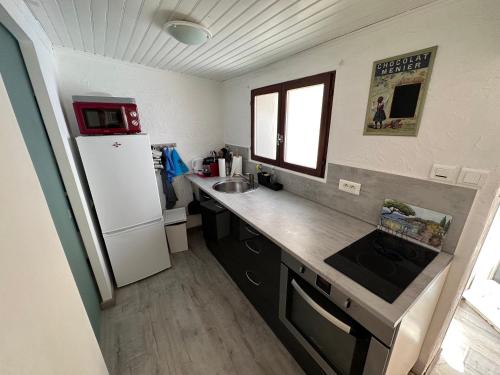 a kitchen with a white refrigerator and a sink at Studio les Iris climatisé, entre mer et collines, classé meublé de tourisme 2 étoiles in Allauch