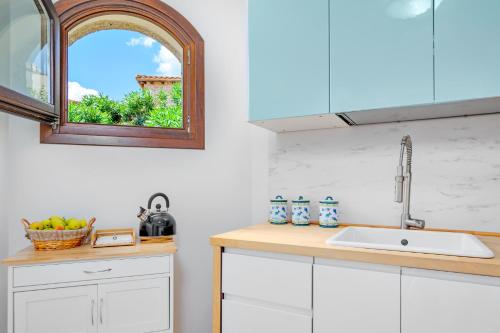 una cocina con fregadero y ventana en Villa BRANDINCHI - Heated Pool, Private Beach, Sea View, Wi-Fi, en San Teodoro
