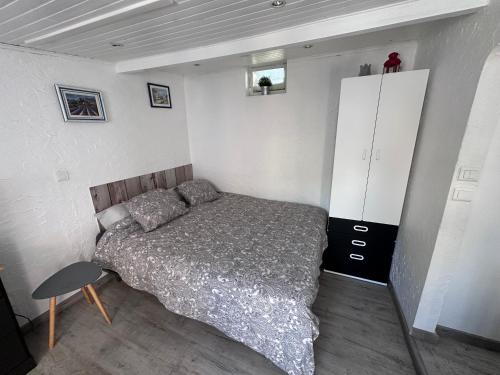 a bedroom with a bed and a cabinet in it at Studio les Iris climatisé, entre mer et collines, classé meublé de tourisme 2 étoiles in Allauch