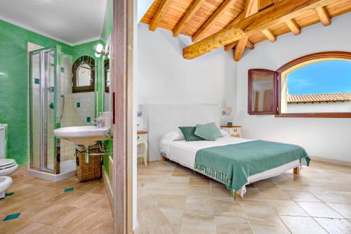 Un dormitorio con una cama y un lavabo y un baño. en Villa BRANDINCHI - Heated Pool, Private Beach, Sea View, Wi-Fi, en San Teodoro
