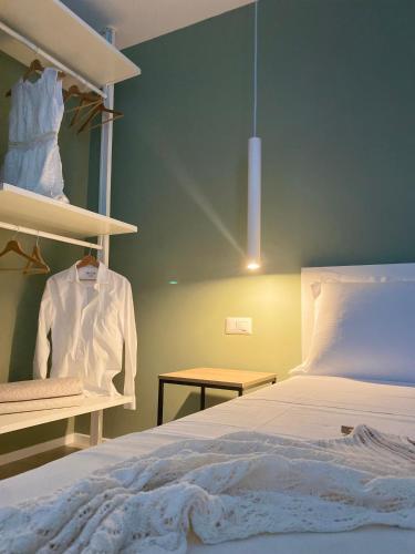a bedroom with a bed and a shirt on a shelf at VIESTEROOMS in Vieste