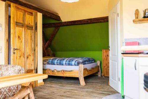 a bedroom with green walls and two beds in it at Schwalbenwohnung 