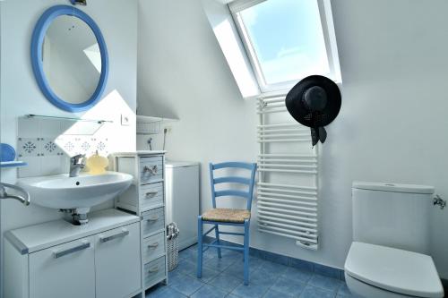 uma casa de banho com um lavatório, um espelho e um WC. em Cap Frehel gîte 4 personnnes em Frehel