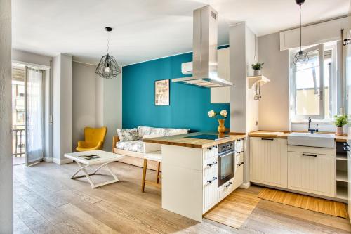 a kitchen with blue walls and a couch at ALTIDO Delightful flat with terrace in Milan