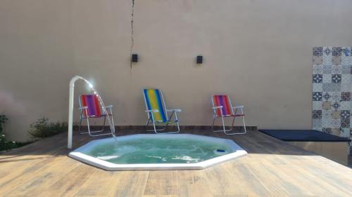 a hot tub in a room with three chairs at Casa c/ quartos separados + churrasqueira ampla. in Brotas