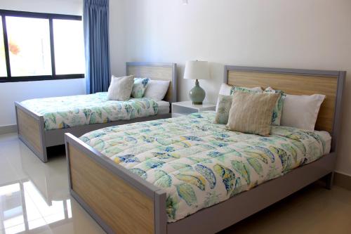 a bedroom with two beds and a window at Amar'e Aparthotel & Spa in Las Terrenas