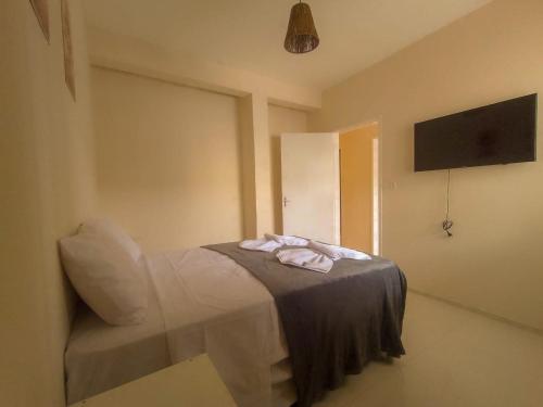 een kamer met een bed met een stoel en een televisie bij Residencial Terrazas in Florianópolis