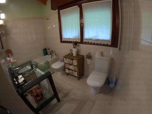 een badkamer met een toilet, een wastafel en een raam bij Casa roja in Marrón