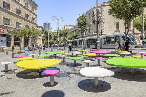 um grupo de mesas numa rua com um comboio em IB Properties Suites em Jerusalém
