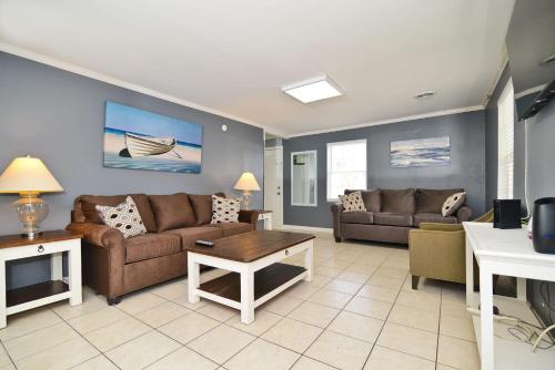 a living room with a couch and a table at Suns Out Steps to Beach w Private Pool in Cherry Grove in Myrtle Beach