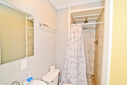 a bathroom with a shower curtain and a toilet at Suns Out Steps to Beach w Private Pool in Cherry Grove in Myrtle Beach