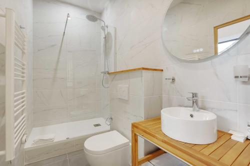 een badkamer met een wastafel, een toilet en een spiegel bij Superb 6P apartment next to Bastille Voltaire in Parijs