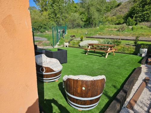 a garden with two wooden barrel chairs on the grass at El txoko de onso in Santibáñez de la Peña