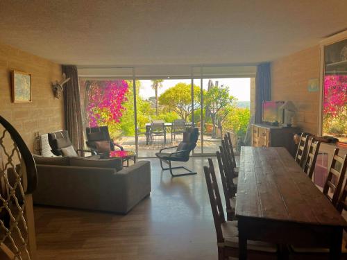 - un salon avec une table, un canapé et des chaises dans l'établissement Le Plein Sud, à Cassis