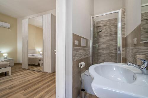 a white bathroom with a sink and a shower at Vico Rooms in Sassari