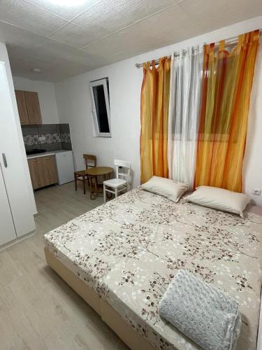 a bedroom with a bed with an orange curtain at Simeona2 in Buljarica