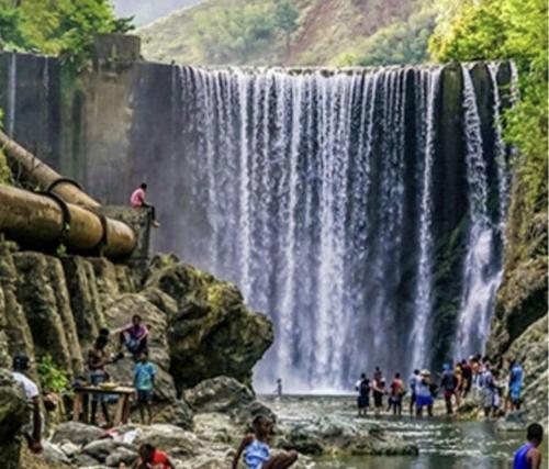 a group of people standing in front of a waterfall at Seacret Studios - Cozy Jamaican Retreat apts in Negril