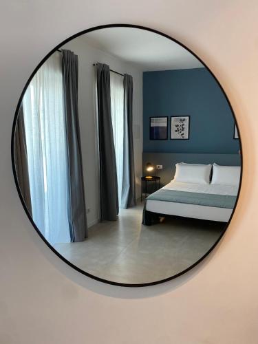 a bedroom with a bed and a mirror on a wall at VIESTEROOMS in Vieste