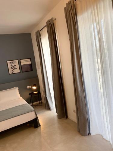 a bedroom with a bed and a window with curtains at VIESTEROOMS in Vieste