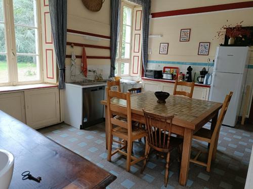 La cuisine est équipée d'une table, de chaises et d'un réfrigérateur. dans l'établissement Manoir près de La Baule, à Saint-Lyphard