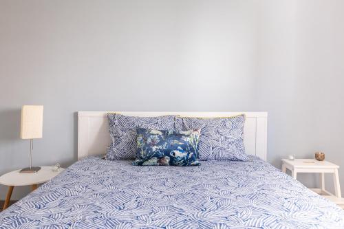 un letto con un piumone blu e due cuscini di 1 Bedroom Beach Apartment with Balcony 2 min walk to the beach! a Costa da Caparica