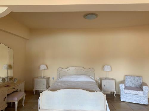 a bedroom with a bed and two tables and a chair at Endless Seaview in Porto Rafti