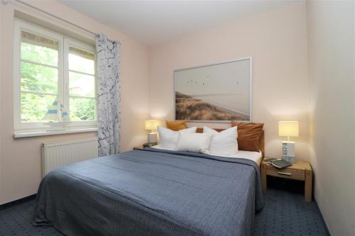 阿伦斯霍普Haus Kienappel Haus Kienappel, App 01的一间卧室设有蓝色的床和2个窗户。