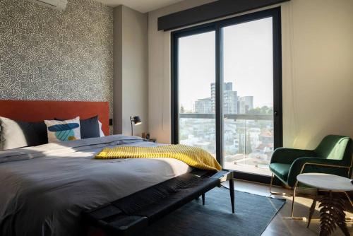 een slaapkamer met een bed en een groot raam bij Amazing 2-bedrooms Condo in Guadalajara