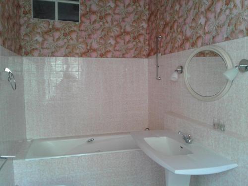 a bathroom with a tub and a sink and a mirror at Manoir près de La Baule in Saint-Lyphard