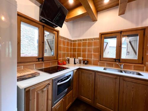 a kitchen with wooden cabinets and a stove top oven at Casa L'Isard - Anàs 