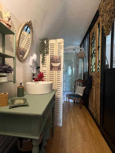 a bathroom with a sink and a table and a chair at VILLA NOTRE DAME face au Château fort in Sedan