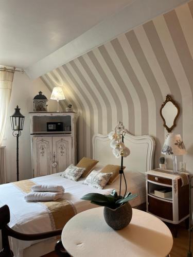 a bedroom with a white bed and a table at VILLA NOTRE DAME face au Château fort in Sedan