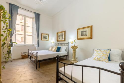 um quarto com duas camas e uma janela em Gentile Suites em Roma