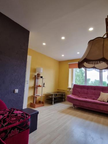 a living room with a purple couch and a window at Entire apartment in Pakruojis in Pakruojis