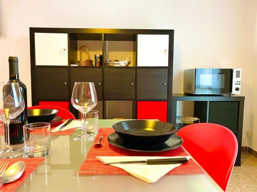 a table with red chairs and a black bowl on it at HOME - Alessandra Holiday House in Piove di Sacco