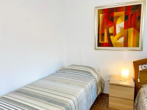 a bedroom with a bed and a painting on the wall at HOME - Alessandra Holiday House in Piove di Sacco