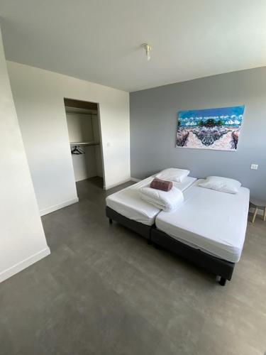 une chambre avec un lit et un tableau au mur dans l'établissement Maison Moderne Avec Piscine Chauffée Dans la Baie du Mont st Michel 200m2, à Yquelon